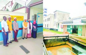 Community leaders standing in front of Supa Loaf-branded plaque marking completed renovations supported by Mini Group at Mvita Health Care Centre"